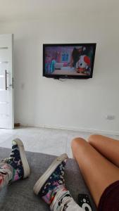 a person sitting on the floor in a living room watching tv at Casa a estrenar equipada para 4 personas in Mar del Plata