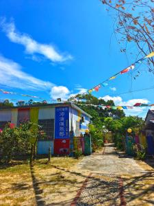 una calle con un edificio y un cielo azul en Wan Ning Xiao Gang Guest House en Wanning
