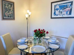 a dining room table with plates and flowers on it at Queens Hill in Edinburgh