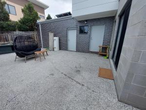 a chair sitting on a patio next to a building at bamboo in Apollo Bay