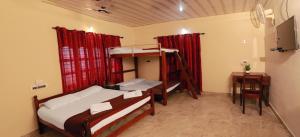 Kaniyāmbetta的住宿－Kudajadri Cottage，一间带两张双层床和电视的卧室