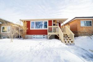 a house with a staircase in the snow at Cozy 3 Bedroom Contemporary Home With Free Parking in Edmonton
