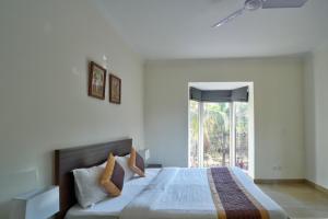una camera con un grande letto e una finestra di 4BHK Luxury Villa with Private Pool Near Candolim a Marmagao
