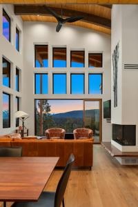 a living room with a fireplace and large windows at Barrel Ridge at Suncadia in Cle Elum
