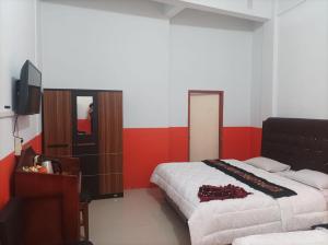 sypialnia z 2 łóżkami i telewizorem w obiekcie Hotel Al Madinah Bangkinang w mieście Bangkinang