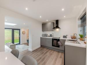 uma cozinha e sala de estar com paredes brancas e pisos de madeira em The Bunker - Uk40225 em Bardon Mill