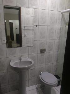 y baño con lavabo, aseo y espejo. en Vila Vitoria Hospedagens en Telêmaco Borba