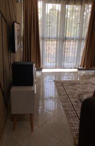 a living room with a tv on a dresser and a floor at Brooks apartments in Kampala