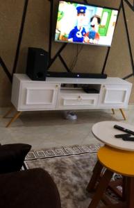 a tv sitting on top of a white entertainment center at Brooks apartments in Kampala