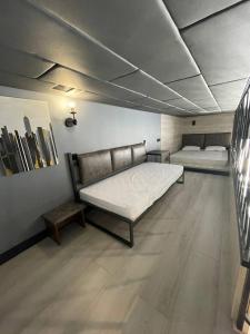a room with two beds and a bench in it at Promenade Burabay halal-apartments (no alcohol, no unmarried couples)) in Borovoye