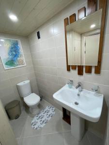 La salle de bains est pourvue d'un lavabo blanc et de toilettes. dans l'établissement Promenade Burabay halal-apartments (no alcohol, no unmarried couples)), à Borovoe