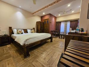 a bedroom with a bed and a desk in a room at Khamma Heritage in Jodhpur