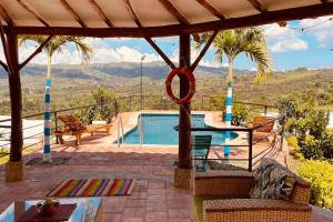 un patio con piscina, tavolo e sedie di Casa campestre mediterraneo a Barichara