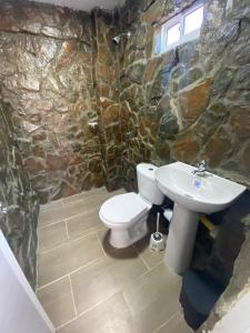 a stone bathroom with a toilet and a sink at Magic horizont in Taganga