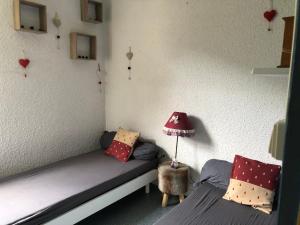 - une chambre avec deux lits et une lampe dans l'établissement Le Bois des Lièvres, à Saint-Pierre-de-Chartreuse