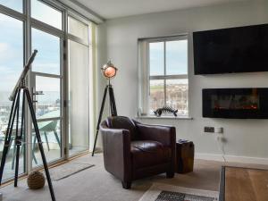 a living room with a chair and a large window at Quayside7 in Whitehaven