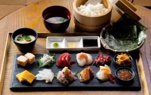 un tavolo con un piatto di sushi e altri prodotti alimentari di The Ryokan Tokyo YUGAWARA a Yugawara