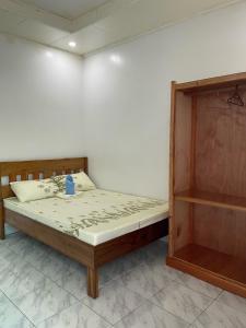a bedroom with a bed and a wooden cabinet at Dhong and Eden Home in San Vicente