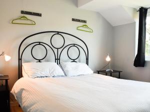 a bedroom with a white bed with two pillows at Sidelands Sojourn in Stratford-upon-Avon
