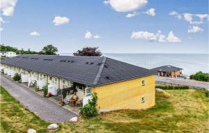 a yellow house with a black roof and the ocean at 2 Bedroom Stunning Apartment In Allinge in Allinge