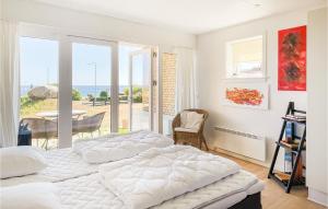 two beds in a bedroom with a view of the ocean at 2 Bedroom Stunning Apartment In Allinge in Allinge