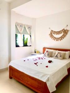 - une chambre avec un grand lit orné de roses dans l'établissement JEJU Beach Front Villa, à Tam Kỳ