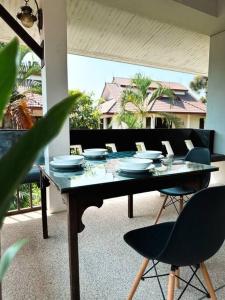 una mesa de comedor con sillas y platos. en SID house en Ban Hua Laem Ma So