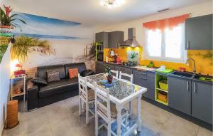 cocina y sala de estar con mesa y sofá en 1 Bedroom Gorgeous Home In Capestang, en Capestang