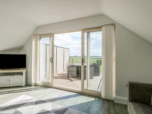 una sala de estar con una gran puerta corredera de cristal en The Attic, en Kings Lynn