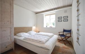 a bedroom with a bed and a chair in it at Holiday Home Præstekraven Rømø in Rømø Kirkeby +25 photos
