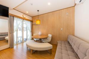 a living room with a couch and a table at HOPETREE CoCo HAPPO TOWNS in Hakuba