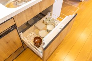 un cajón abierto en una cocina con platos en HOPETREE CoCo HAPPO TOWNS, en Hakuba