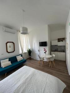 Una sala de estar con un sofá azul y una mesa. en Fior di Loto Suite - Antonelli, en Turín