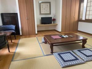 uma sala de estar com uma mesa de centro e uma televisão em 湯布院 おやど花の湯yufuin oyado hananoyu em Yufu