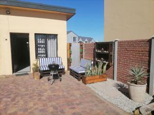 a patio with two chairs and a grill at @Kitchens in Jeffreys Bay