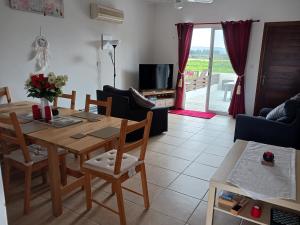 un soggiorno con tavolo e sedie in legno di Beautiful 2-Bed House in Mandria paphos a Mandria