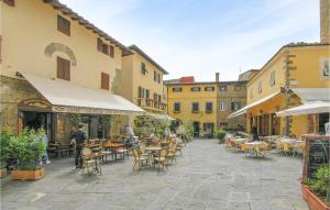 um pátio exterior com mesas, cadeiras e edifícios em Nice Home In Colle Di Buggiano With Kitchen em Colle di Buggiano