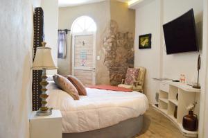 a bedroom with a bed and a chair and a window at Hotel de Piedra in Bernal