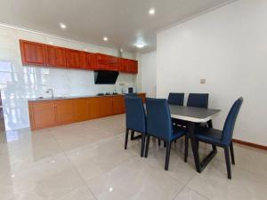 a kitchen with a dining table and blue chairs at 2 bedroom Apartment in Nadi