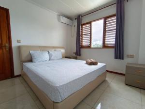 um quarto com uma cama com um urso de peluche em 2 bedroom Apartment em Nadi
