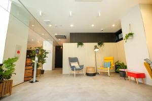 ein Wartezimmer mit zwei Stühlen und einem Tisch in der Unterkunft ELE Hotel Kuzuha in Hirakata