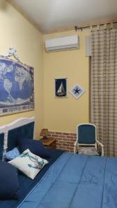 una camera con un letto blu e una sedia di Villa Maddalusa a Agrigento