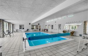 una piscina en una habitación grande con un techo grande en Lovely Home In Blvand With Indoor Swimming Pool, en Blåvand