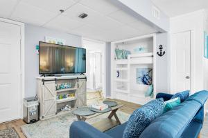 ein Wohnzimmer mit einem blauen Sofa und einem TV in der Unterkunft Long Beach Resort 1-1300E in Panama City Beach