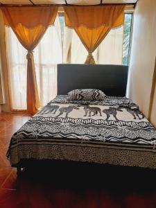 1 dormitorio con 1 cama con edredón blanco y negro en Habitaciones Isa; lugar para tu descanso, en Armenia