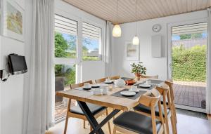 uma sala de jantar com uma mesa de madeira e cadeiras em Gorgeous Home In Hejls With Kitchen em Hejls