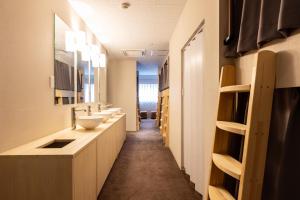 un baño con 2 lavabos y un pasillo largo en Akasaka The Hostel, en Tokio