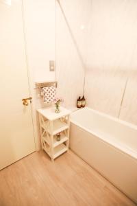 a white bathroom with a tub and a table at Woodside Oak hot tub & pool sleeps 4-6 in Bideford