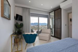 a bedroom with a bed and a chair and a window at Villa Nick Art in Lithakia