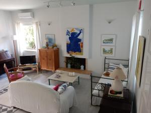 Villa Feia في كاتاكولو: غرفة معيشة مع أريكة بيضاء وطاولة